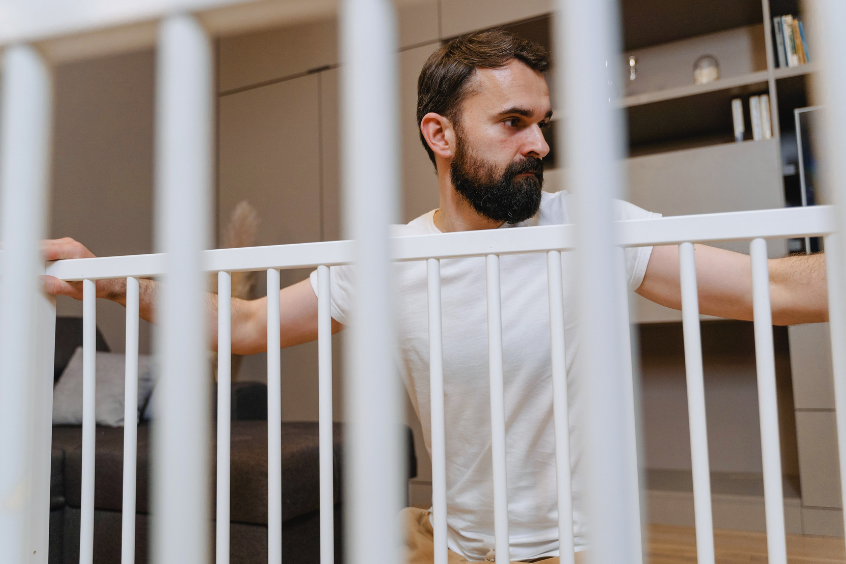Father checking a baby gate inside his home 