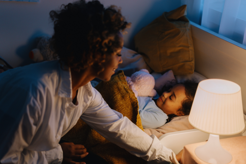 A mother putting her daughter to bed
