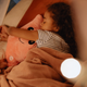 A young girl embracing a pink plush toy while sleeping comfortably in her cozy bed
