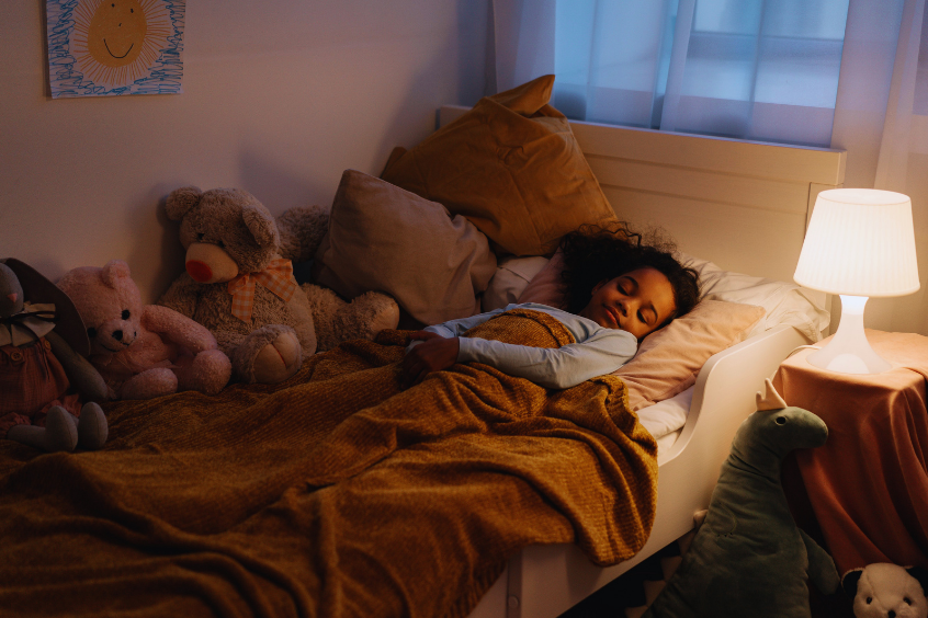 A young child sleeping peacefully in her own bed at night 