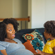 Pregnant mother talking with her daughter while in the couch at home